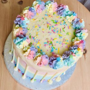 Top of bright, colourful rainbow pinata drip cake