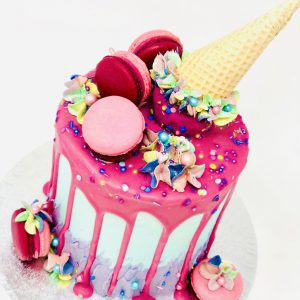 Unique pink gourmet birthday drip cake with ice cream cone topping