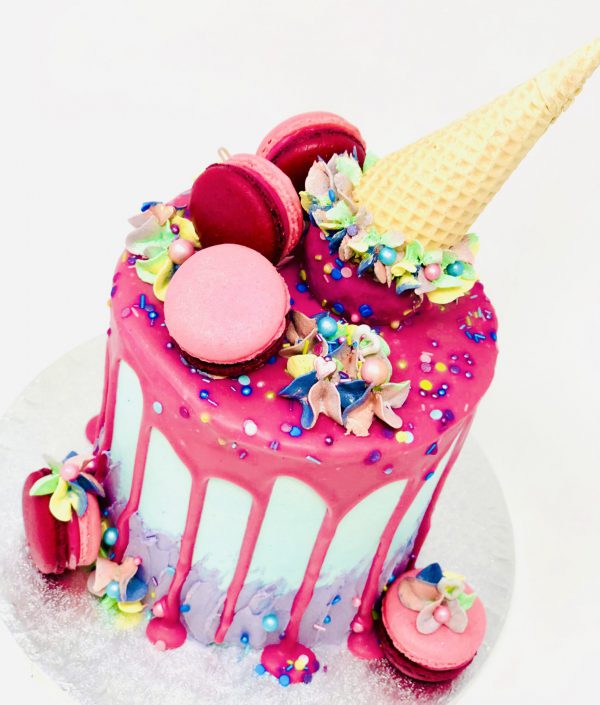Unique pink gourmet birthday drip cake with ice cream cone topping