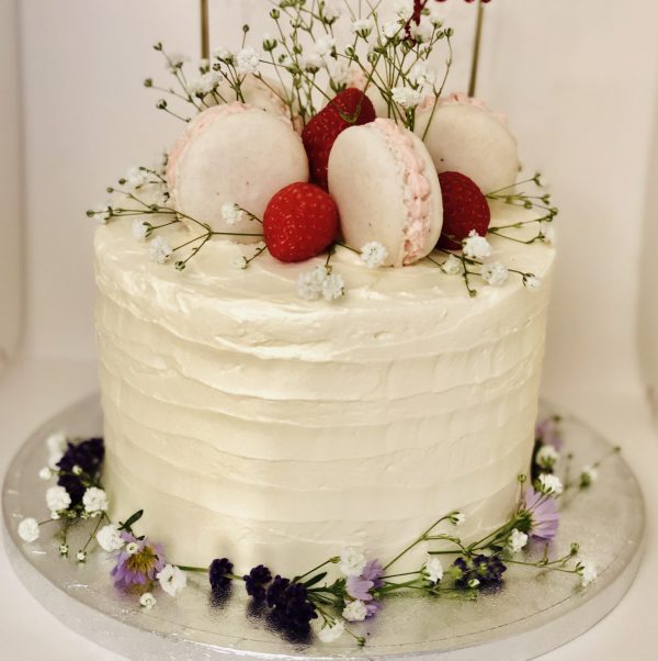 Handcrafted luxury French macaron and strawberry cake, decorated with fresh flowers