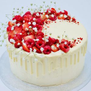 Handcrafted strawberry, raspberry and lemon drip cake topped with fresh fruits