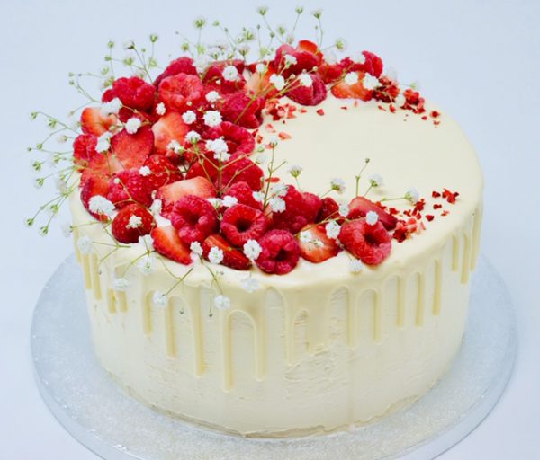 Handcrafted strawberry, raspberry and lemon drip cake topped with fresh fruits