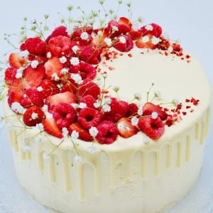 beautiful gourmet mothers day cake topped with flowers and raspberries