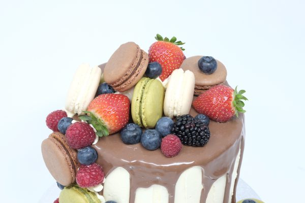 Top of luxury celebration cake with freshly baked macarons and fruits