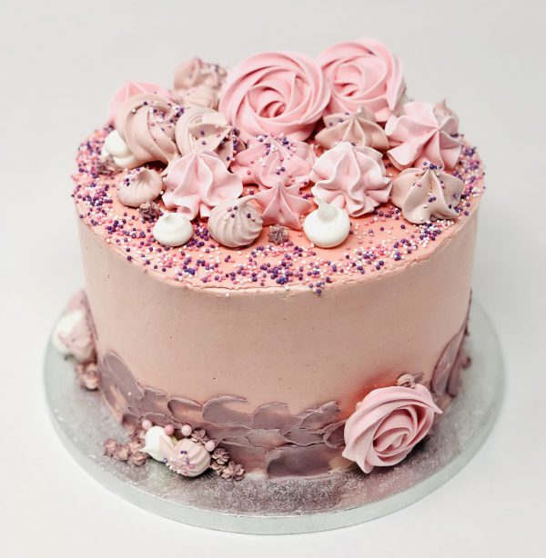 Handcrafted baby pink swirl cake with freshly baked meringue kisses