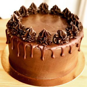 Indulgent handmade dark chocolate cake with chocolate icing and drip ganache topping