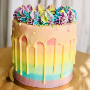 Rainbow layer sponge birthday cake with handmade colourful icing and sprinkles