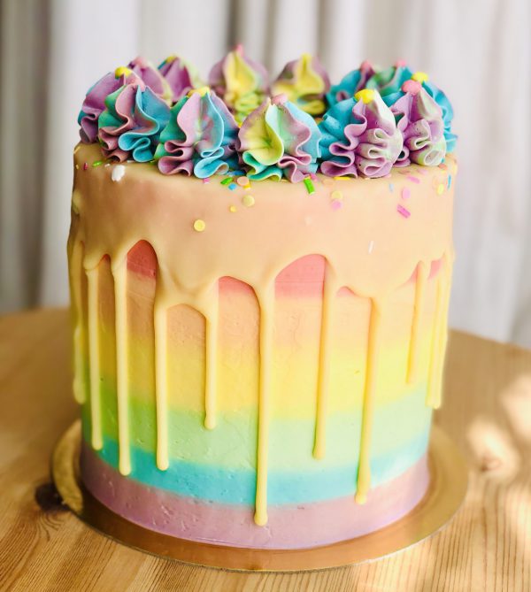 Rainbow layer sponge birthday cake with handmade colourful icing and sprinkles