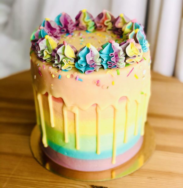 Unique colourful birthday pinata cake with vanilla drip