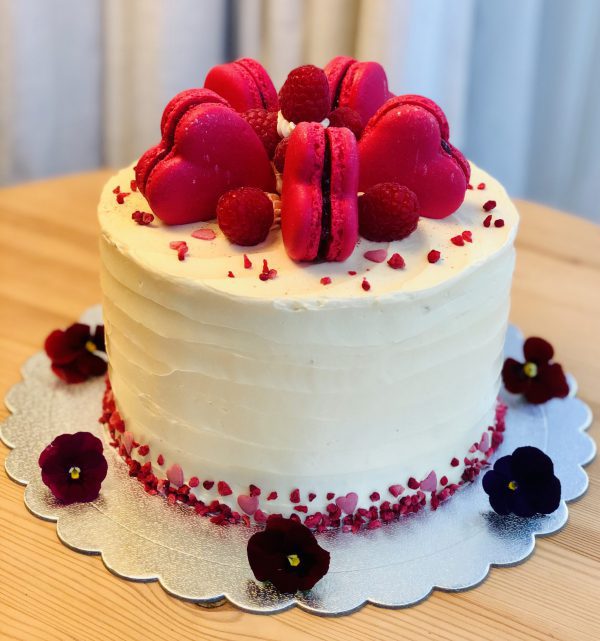 Handcrafted raspberry and vanilla sponge cake topped with pink macarons