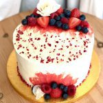 Elegant strawberry and vanilla celebration cake with fresh flowers and berries