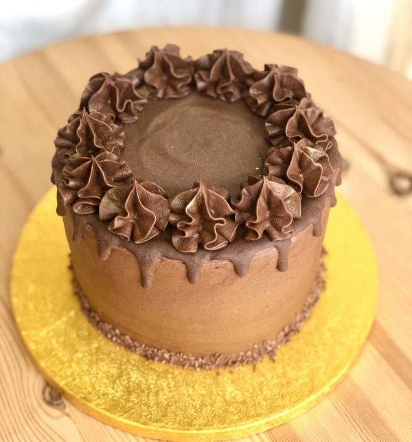 Chocolate icing on decadent celebration cake with drip topping and chocolate ganache