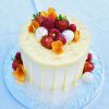 Handmade vanilla cake with drip detail and topping of fresh berries